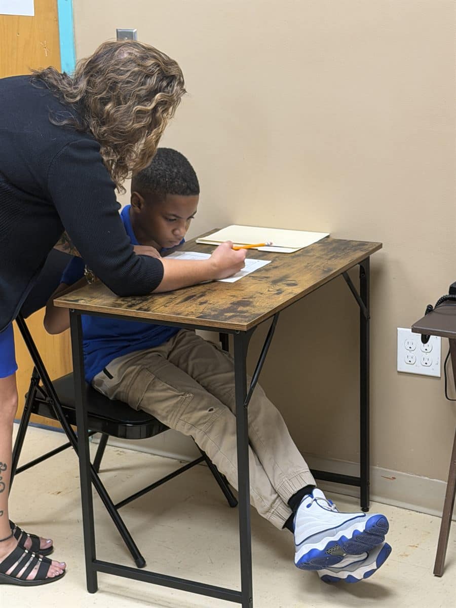 School counselor helping a student one-on-one at a desk during a school-day session